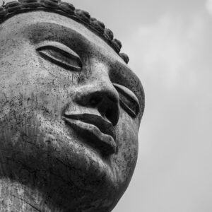 Close-up view of a stone Buddha statue in monochrome, capturing the essence of spirituality.